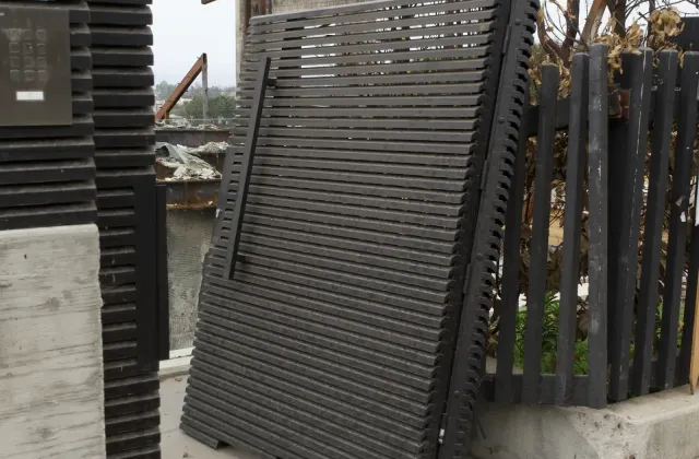An aluminum gate panel left standing on a burned-out property after the Palisades fire