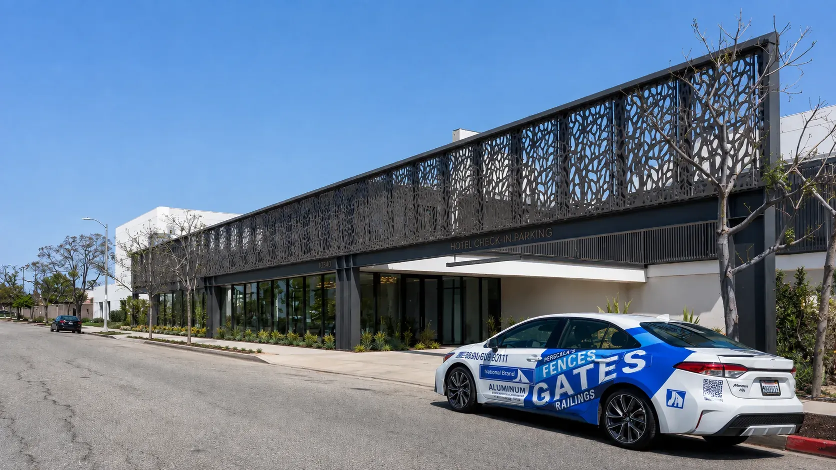 A hotel check-in canopy fronted by a long laser-cut aluminum screen running the length of the drive