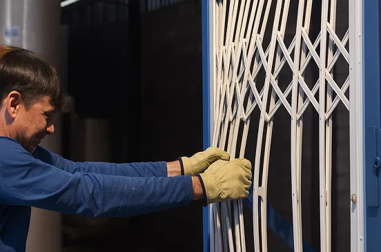 A Mulholland installer drawing a retractable security gate across an opening
