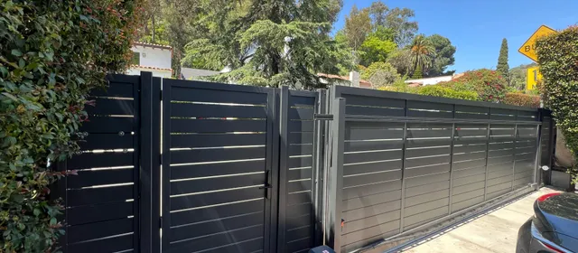 Dark horizontal-slat aluminum driveway gate, open
