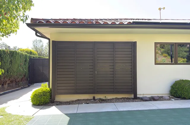 Aluminum equipment enclosure beside a house