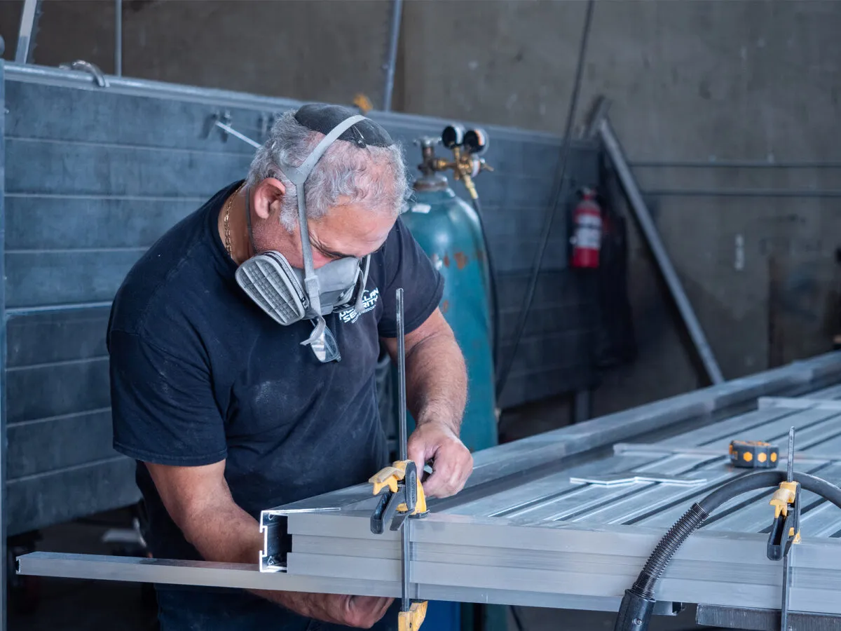 A fabricator working an aluminum gate frame