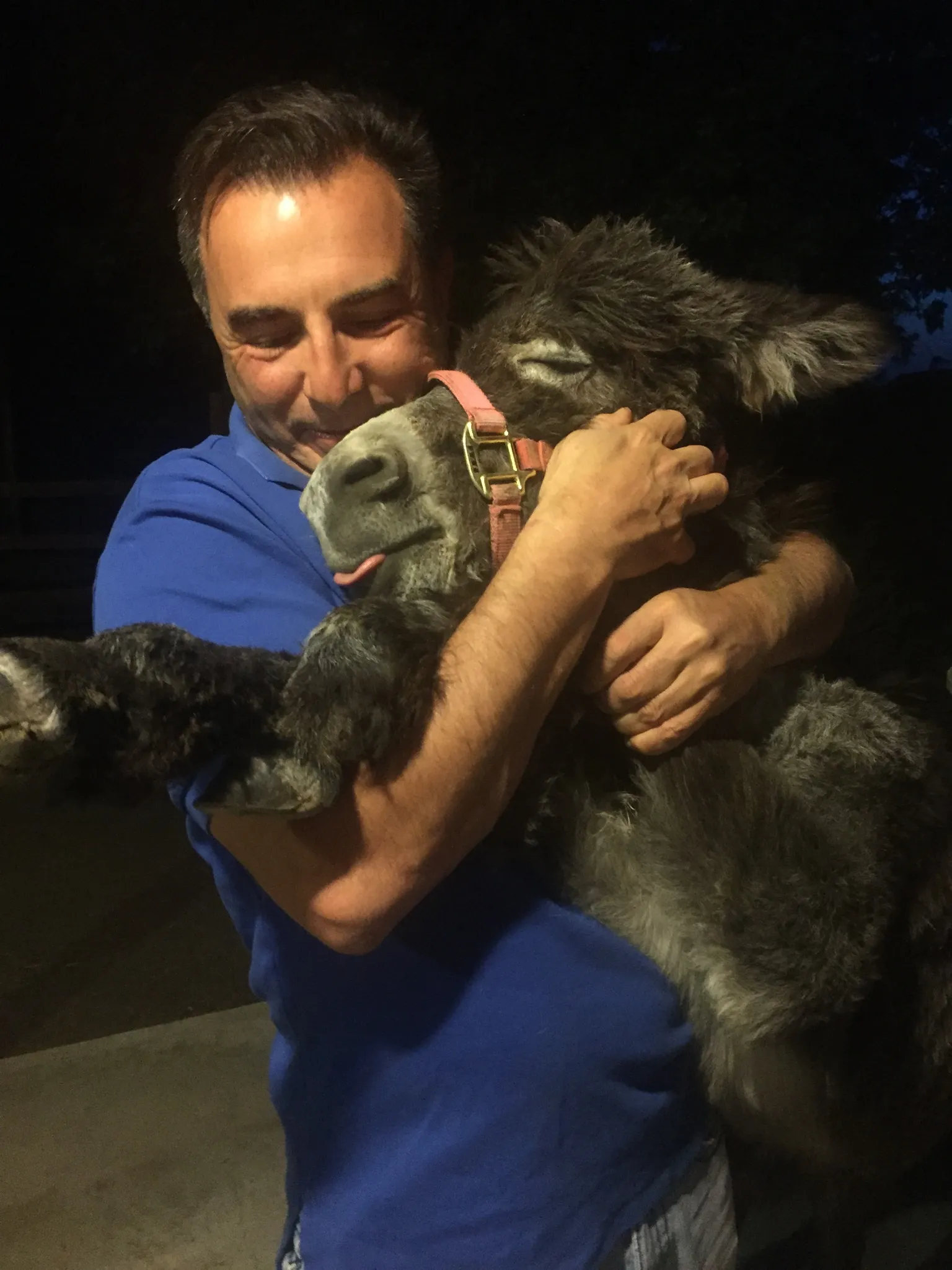 A man in a blue shirt hugging young Myka close at night