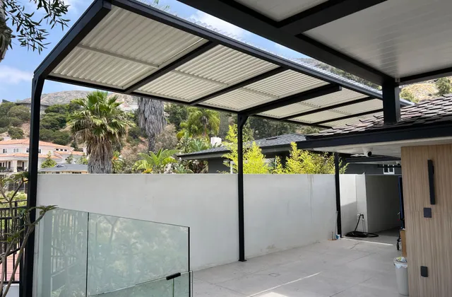 White aluminum pergola over a patio, palms behind it