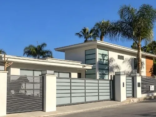 Light grey aluminum slat fence between white pillars along a single-storey home