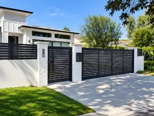 Black slat aluminum driveway gate and walk gate between white brick pillars