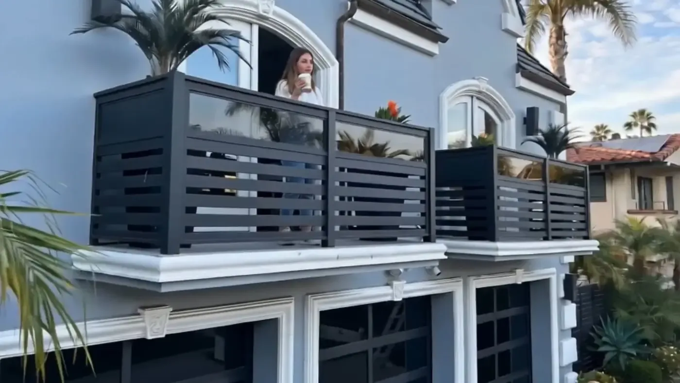 An aluminum and glass railing along a raised terrace.