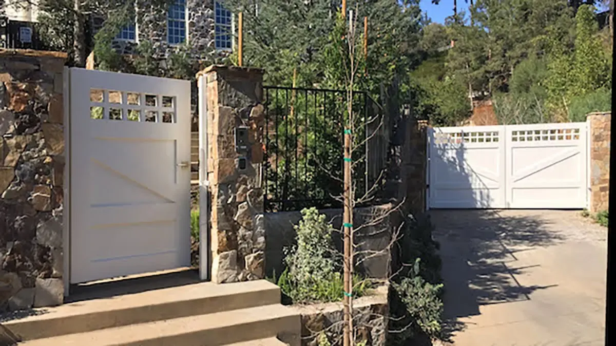 White hillside driveway gate and entry gate