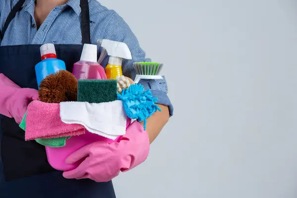 young girl holding cleaning materials